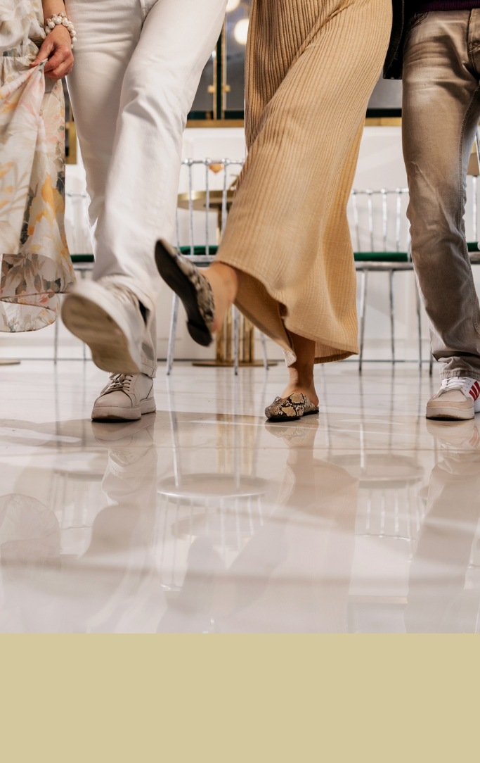 Close up view of people's legs and feet participating in line dance.
